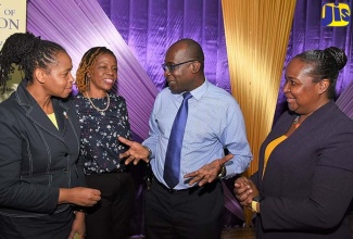 Education, Youth and Information Minister, Senator the Hon. Ruel Reid (second right), converses with Assistant Chief Education Officer, Dasmine Kennedy (left), and Regional Director,  Dr. Nadine Leachman (second left), during the Ministry’s Region Five Parent Sensitisation Session at Bishop Gibson High School in Mandeville, Manchester, on Tuesday (October 23). Also listening is Chief Education Officer, Dr. Grace McLean.