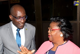 Minister of Education, Youth and Information, Senator the Hon. Ruel Reid (left), listens to Director General, Public Sector Transformation and Modernisation Programme, Office of the Cabinet, Veniece Pottinger-Scott, at the launch of the Records and Information Management (RIM) Policy Implementation and Sensitisation Programme on Thursday (October 4) at the Jamaica Conference Centre in downtown Kingston.