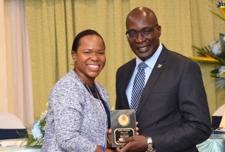 Minister of Education, Youth and Information, Senator the Hon. Ruel Reid (right), presents a plaque to Director of Regional Educational Services, Region One, Dr. Kasan Troupe, during the fourth staging of the Performance Management and Appraisal System (PMAS) awards ceremony, held at The Knutsford Court Hotel in New Kingston on December 4. During the ceremony, persons were recognised for their outstanding performance during the 2017/18  period. 