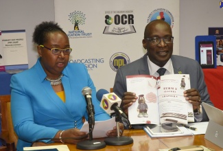 Chief Education Officer in the Ministry of Education, Youth and Information,  Dr. Grace McLean (left),  gives details of the Primary Exit Profile (PEP) examinations to be held in 2019, as Minister of Education, Youth and Information, Senator the Hon. Ruel Reid,  displays one of the Cheetah PEP practice books, at the Ministry's Quarterly Press Briefing, held at their offices in downtown, Kingston, on December 6.