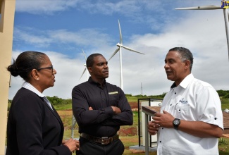 General Manager of Public-Private Partnerships and Privatisation Services at the Development Bank of Jamaica (DBJ), Denise Arana (left) listens attentively to a point being made by Operations Manager of Wigton Windfarm, Rohan Hay (right) during a tour of the wind farm in Rose Hill Manchester on November 30. Looking on is Deputy General Manager of JN Fund Managers Limited, Jermaine Deans.