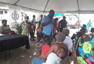 Assistant Commissioner of Police, Steve McGregor (standing with mic), addresses an Early Childhood Commission (ECC)  ‘Pon Di Cawna’ session, which was held in Cassava Piece, St. Andrew, late last year.