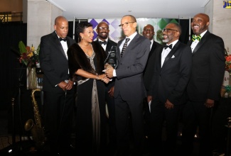 Jamaica’s Ambassador to the United States, Her Excellency Audrey Marks (left, front row) presents the 2018 David “Wagga” Hunt Distinguished Award to Dr. Kevin Asher (centre, front row), the father of Chinyelu Asher, a member of Jamaica’s senior football women’s team, at the David “Wagga” Hunt Scholarship Fundraising Gala, held on Saturday, January 19 in Washington DC. Others in the photo are members of the organising committee of the David “Wagga” Hunt Scholarship Fund.

