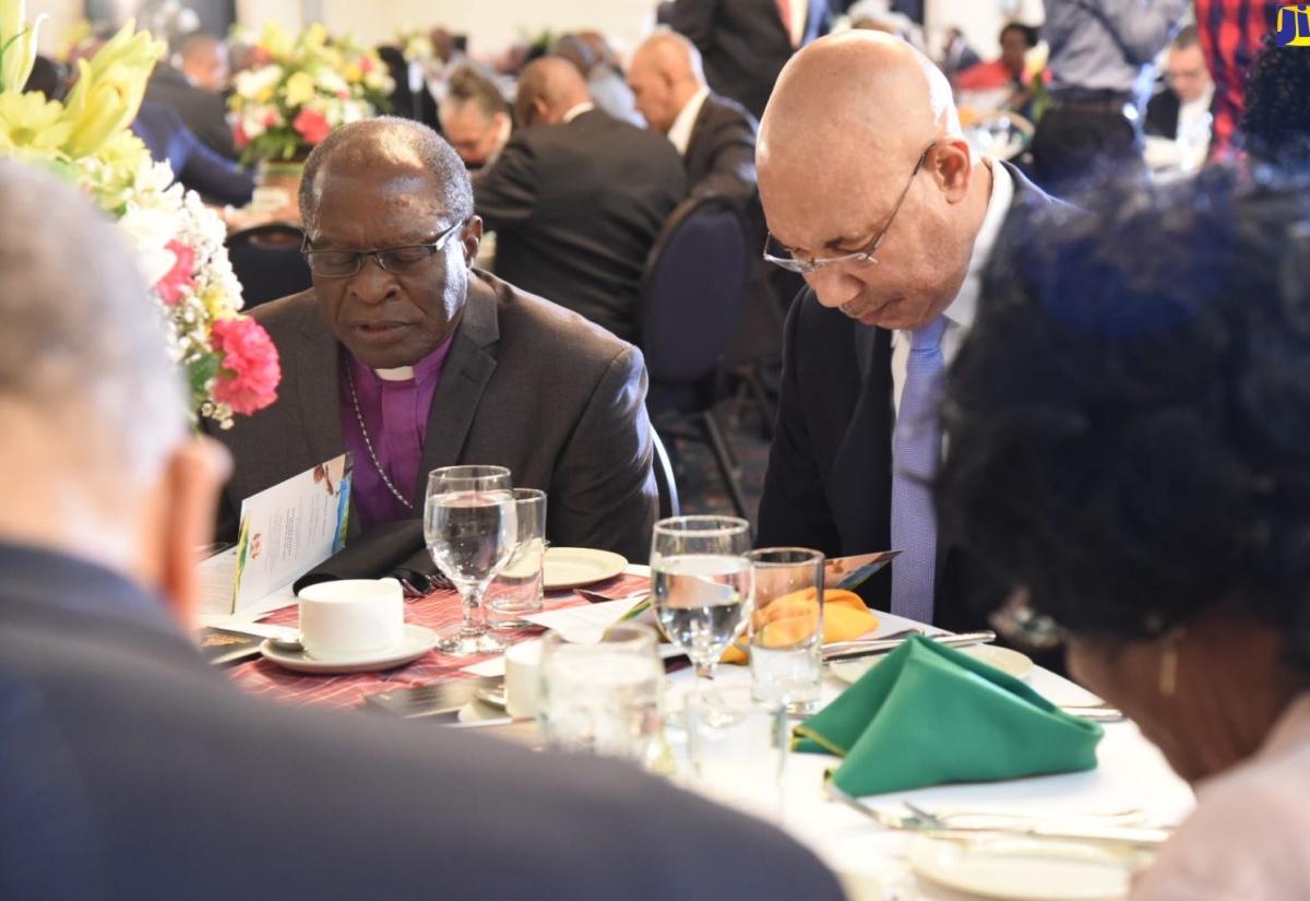 Governor-General,  His Excellency the Most Hon. Sir Patrick Allen (right) and Vice President, National Leadership Prayer Breakfast, Bishop Stanley Clarke, bow their heads in prayer at the  39th annual National Leadership Prayer Breakfast, held at The Jamaica Pegasus hotel in New Kingston, on Thursday (January 17). 