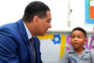 Prime Minister, the Most Hon. Andrew Holness (left), listens to five-year-old Makai McLawrence, at Small Treasures Child Care, in St. Andrew, on Tuesday (January 8). Makai wrote a letter to the  Prime Minister during the holiday season, inviting him to the school.  