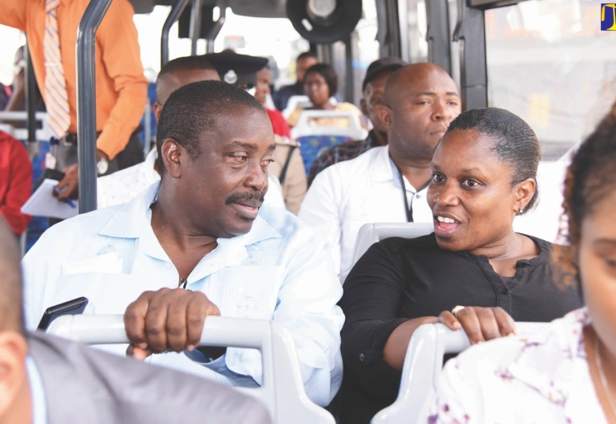 Transport and Mining Minister, Hon. Robert Montague, converses with a member of the public during a Jamaica Urban Transit Company (JUTC) bus ride from Three Miles to Half-Way Tree in St. Andrew.