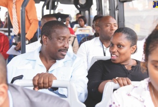 Transport and Mining Minister, Hon. Robert Montague, converses with a member of the public during a Jamaica Urban Transit Company (JUTC) bus ride from Three Miles to Half-Way Tree in St. Andrew.