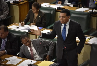 Prime Minister, the Most Hon. Andrew Holness, addresses the House of Representatives on February 5.  Others (from left) are Minister of Industry, Commerce, Agriculture and Fisheries, Hon. Audley Shaw, and Finance and the Public Service Minister, Dr. the Hon. Nigel Clarke.  Attorney General, Hon. Marlene Malahoo Forte, is also present. 