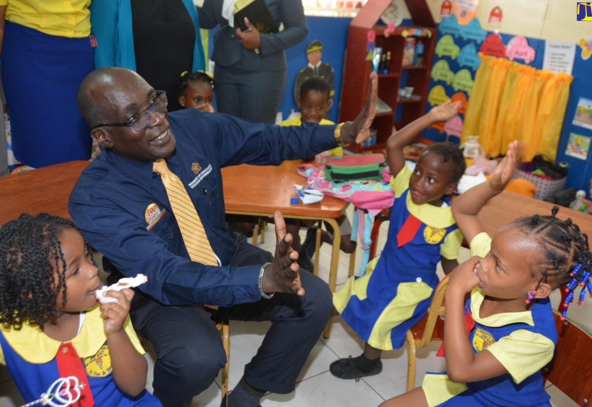 Minister of Education, Youth and Information, Senator the Hon. Ruel Reid, interacts with students of the Liberty Hill Infant School in Discovery Bay, St. Ann, at the institution’s reopening on Wednesday (February 20).