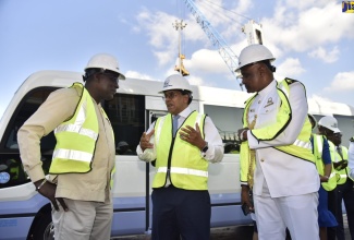 Minister of Education, Youth and Information, Senator the Hon. Ruel Reid (left); and President, Caribbean Maritime University (CMU), Professor Fritz Pinnock (right), listen to Chief Executive Officer, Kingston Wharves Limited (KWL), Dr. Grantley Stephenson, during a tour of the entity's  Total Logistics Facility at Newport West, Kingston on Wednesday (February 6). Prior to the tour, the KWL and CMU exchanged documents for a partnership  between the enitities to advance research in the port and logistics sector.