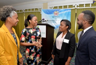 Senior Director of Transport Policy in the Transport and Mining Ministry, Tanya Bedward (second left),  converses with Acting Director of Documentation/Information and Access Services in the Ministry, Carene Harris (second right), at a consultation on the National Transport Policy (NTP), at The Knutsford Court Hotel in New Kingston on February 21. Also sharing in the discussion are Chief Technical Director in the Ministry, Dr. Janine Dawkins (left); and Senior International Transport Policy Officer in the Ministry, Hassin Fulton.