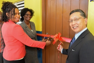 Ambassador of Japan to Jamaica, His Excellency Hiromasa Yamazaki (right); Principal of  Care Bear Early Childhood Development Centre, Cynthia Roach-Porter (left); and Deputy Chief Education Officer, Dasmine Kennedy, cut the ribbon to officially open a new building at the institution located on Waltham Road in St. Andrew on Tuesday (February 26).   The project was undertaken through $12 million in funding from the Government of Japan. 