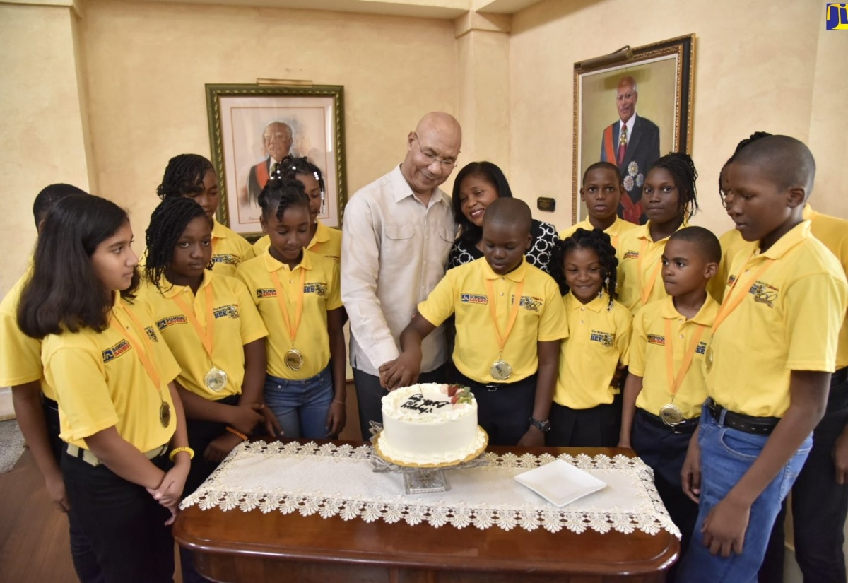 Governor-General, His Excellency the Most Hon. Sir Patrick Allen (fourth left), assists The Gleaner’s Children Own 2018/19 National Spelling Bee Champion, Darian Douglas to cut a cake to celebrate his 12th birthday. Sharing the moment are Her Excellency, The Most Hon. Lady Allen (fourth right, background) and the Spelling Bee parish champions. Occasion was a reception for the parish champions and their teachers and programme representatives on Thursday (February 7) at King’s House.  Douglas will move on to represent Jamaica at the Scripps National Spelling Bee competition in Washington DC later this year.