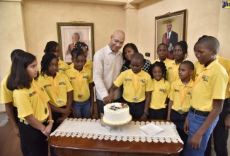 Governor-General, His Excellency the Most Hon. Sir Patrick Allen (fourth left), assists The Gleaner’s Children Own 2018/19 National Spelling Bee Champion, Darian Douglas to cut a cake to celebrate his 12th birthday. Sharing the moment are Her Excellency, The Most Hon. Lady Allen (fourth right, background) and the Spelling Bee parish champions. Occasion was a reception for the parish champions and their teachers and programme representatives on Thursday (February 7) at King’s House.  Douglas will move on to represent Jamaica at the Scripps National Spelling Bee competition in Washington DC later this year.
