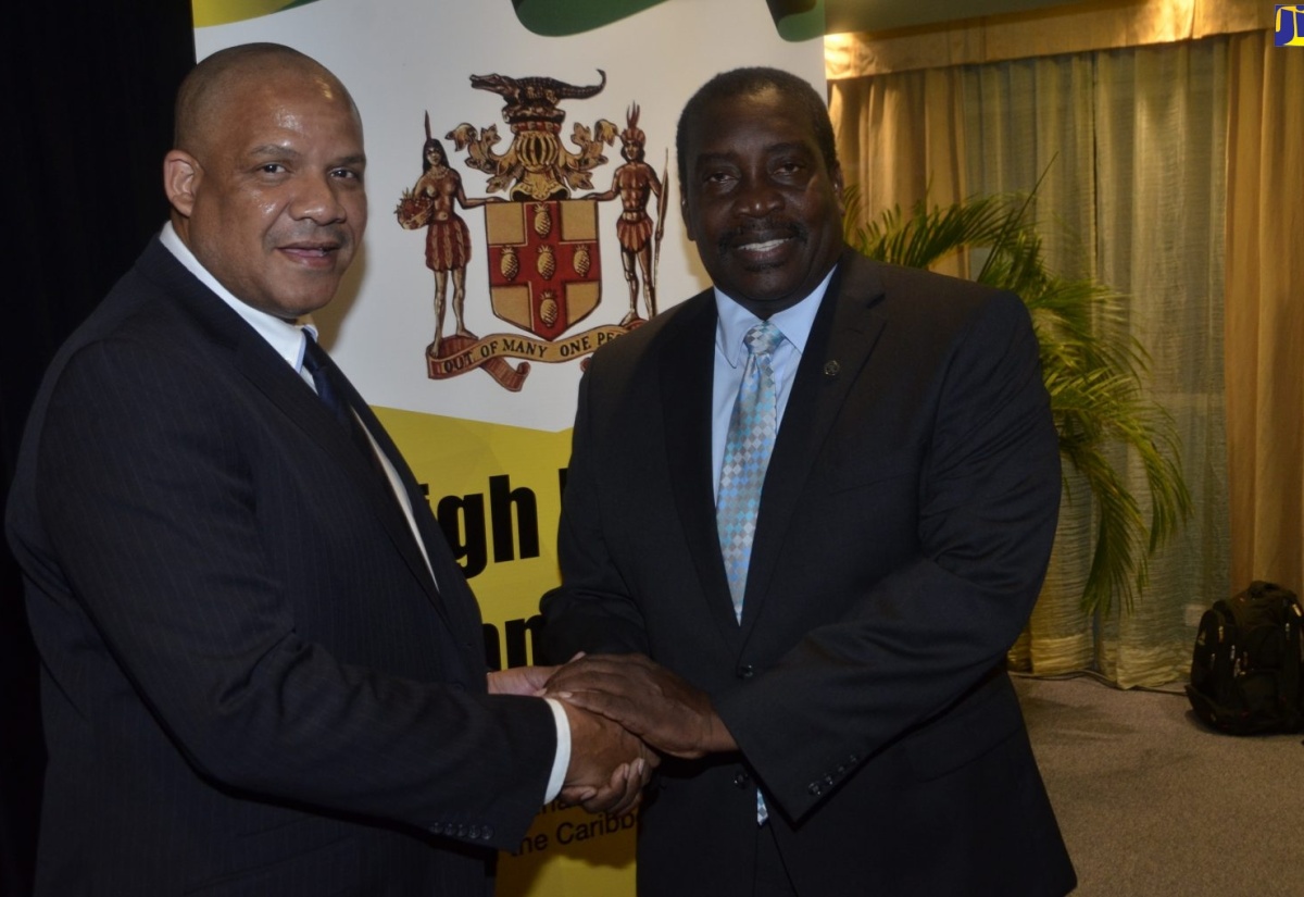 Minister of Transport and Mining, Hon. Robert Montague (right), engages with Maritime Authority of Jamaica’s Director for Safety, Environment and Protection, Steven Spence, during the High Level Symposium for Transport Ministers of the Caribbean Region, held recently at the Iberostar Hotel in Rose Hall,  St. James.