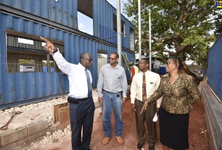 Minister of Education, Youth and Information, Senator the Hon. Ruel Reid (left); and Regional Director, Ministry of Education's Region 5, Dr. Nadine Leachman (right), discuss the new classrooms being built at New Forest Primary and Junior High school in Manchester during a recent tour of the project site. Listening (from second left) are Project Manager, Caribbean Maritime University (CMU), Everold Simms; and Principal of the school, Arnaldo Allen;