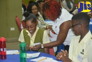 National Coordinator for the Japan Caribbean Climate Change Partnership, Ayesha Constable (centre), interacting with Green Pond High School students, Shymel Hylton (left), and Andre Harriott, at the Post Conference of Parties (COP) Youth Consultation on Climate Change, held at the Wexford Hotel, in Montego Bay, St. James, on  March 29.