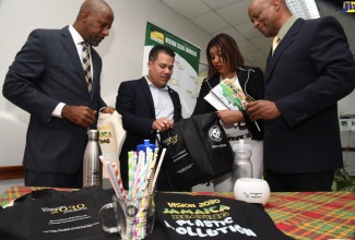 Director General of the Planning Institute of Jamaica (PIOJ), Dr. Wayne Henry (left); and  Director of the Environmental and Conservation Division at the National Environment and Planning Agency (NEPA), Anthony McKenzie (right), look on as Government Senator, Matthew Samuda (second left), examines one of the reusable shopping bags being provided by the  Institute for public distribution.  Programme Director, Vision 2030 Jamaica, Elizabeth Emanuel, highlights the features.  The first 500 of 2,000 bags were presented to Senator Samuda during a ceremony at the PIOJ’s Oxford Road offices in St. Andrew on Monday (March 4). 
 
