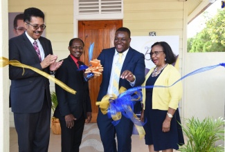 Senior Advisor to the State Minister for Education, Youth and Information, Howard Chamberlain (second right), cuts the ribbon to officially open the University of Technology (UTech) 60th anniversary exhibition on March 4. Sharing the moment (from left) are:  UTech President, Professor Stephen Vasciannie; Deputy President, Colin Gyles, and Campus Registrar, Mercedes Deane. 