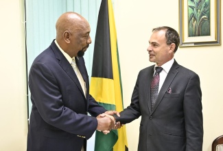 Minister of State in the Ministry of National Security, Hon. Rudyard Spencer, greets National Coordinator of the Housing, Opportunity, Production and Employment (HOPE) Programme, Lieutenant Colonel Martin Rickman, during a meeting on April 9.