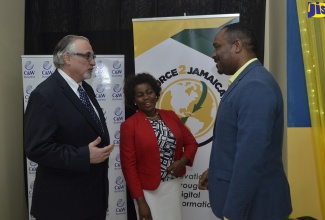 President of the Montego Bay Chamber of Commerce, Winston Lawson; (right) is in discussion with President of the Business Process Industry Association of Jamaica (BPIAJ), Gloria Henry (centre); and Director with responsibility for BPO and Hospitality at Cable and Wireless (C &W) Business Jamaica, Andrew Fazio, at the BPIAJ's Outsource2Jamaica Symposium and Expo 2019 pre-conference mingle, held recently at the Montego Bay Free Zone in St. James.