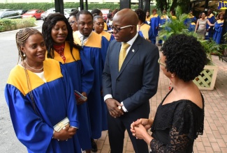 Minister without Portfolio in the Ministry of Economic Growth and Job Creation, Senator Pearnel Charles Jr. (second right) and Chief Executive Officer (CEO) of the Management Institute for National Development (MIND), Dr. Ruby Brown (right), interact  with  graduates  at the 19th Annual Graduation Ceremony of the  institute,  held at the Knutsford Court Hotel, in Kingston, on March 30.