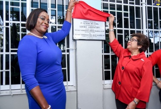 Member of Parliament and past student of St. Catherine High School, the Most Hon. Juliet Holness (left) and Chairman, Digicel Foundation, Jean Lowrie-Chin, unveil a new sign for the renovated science laboratory, which was officially handed over to St. Catherine High School on Wednesday (April 10). 