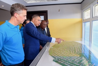 Prime Minister, the Most Hon. Andrew Holness (centre), points out something of interest on the model for the new Silver Sun Estates housing development in St. Catherine. Looking on are Chairman, West Indies Home Contractors Limited (WIHCON),  Peter Melhado (left); Managing Director, WIHCON, Delroy Alcott (second right); and National Housing Trust (NHT) Managing Director, Martin Miller (right). Occasion was the ceremony to break ground for the 1,200-unit housing project on Wednesday (April 24). 