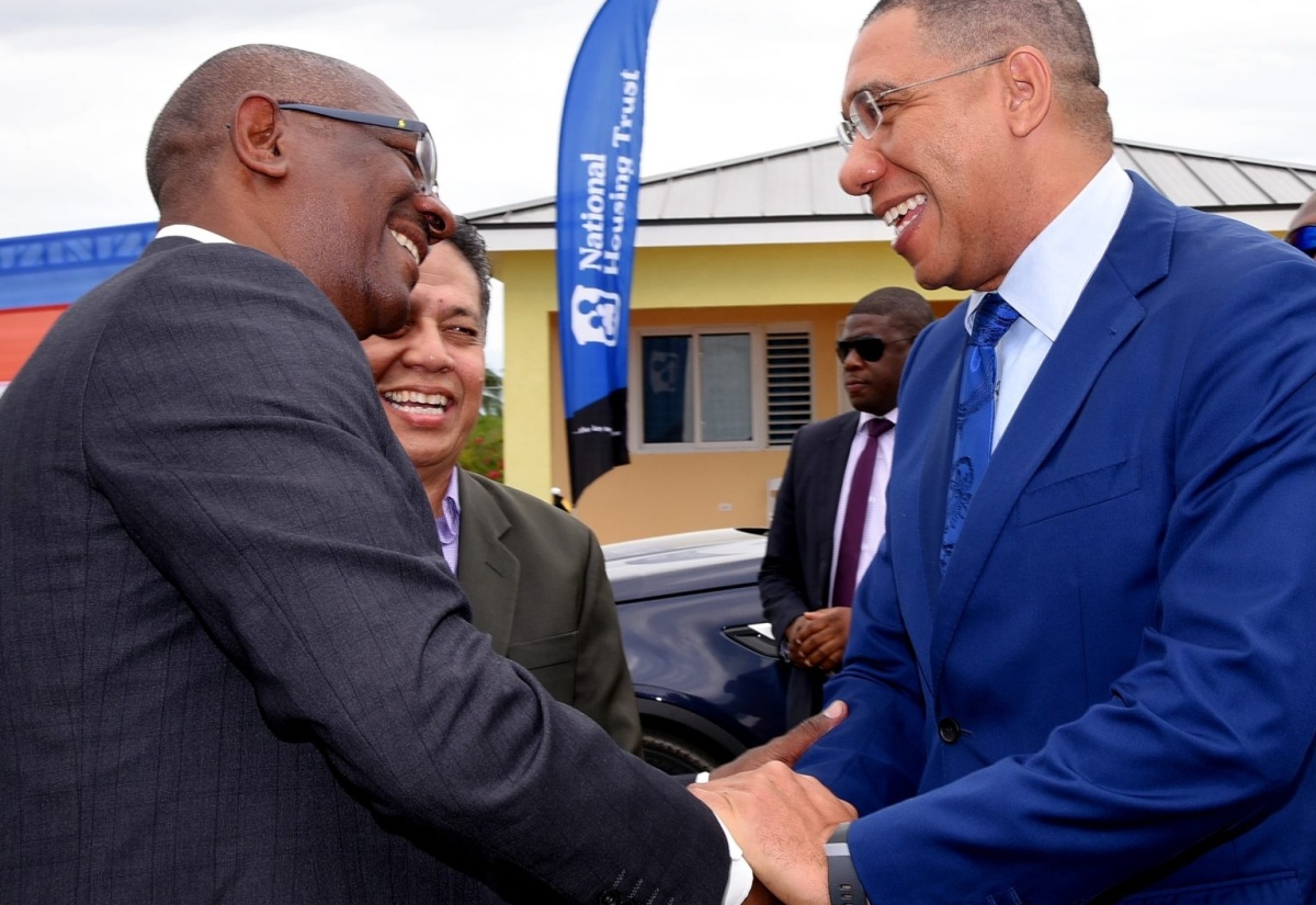 Prime Minister, the Most Hon. Andrew Holness (right), exchanges greetings with Managing Director, National Housing Trust (NHT), Martin Miller (left) before the groundbreaking ceremony for the new Silver Sun Estate housing development in Innswood, St. Catherine on Wednesday (April 24). Sharing the moment is NHT Board Director, David Wan.