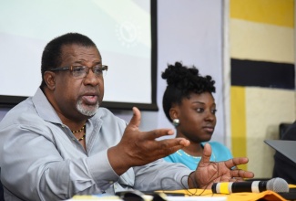 Head of the Jamaica Diaspora Crime Intervention and Prevention Task Force, Dr. Rupert Francis (centre), addresses a public forum on ‘Community Policing: The Role of the Citizen’, at the University of Technology (UTech) on June 13. At right is Executive Director, Youth Crime Watch of Jamaica, Kethania Griffiths.