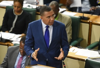 Prime Minister, the Most Hon. Andrew Holness, emphasises a point in the House of Representatives on Tuesday (July 23). At left is Finance and the Public Service Minister, Dr. the Hon Nigel Clarke.