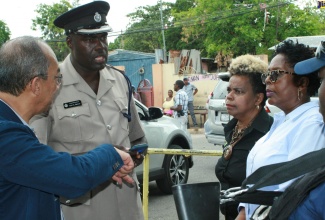 Minister of National Security, Hon. Dr. Horace Chang (left), makes a point to Head of the South St. Andrew Police Division, Superintendent Gary Francis (2nd left), while on a tour of communities in the area on July 26. Also listening are: Permanent Secretary in the Ministry, Dianne McIntosh (2nd right), and Member of Parliament for South West St. Andrew, Dr. Angela Brown Burke.