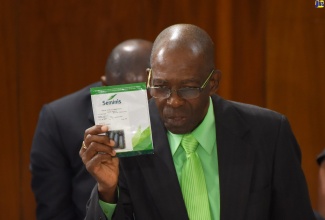 Minister without Portfolio in the Ministry of Industry, Commerce, Agriculture and Fisheries, Hon. J.C. Hutchinson, displays a package of seeds as he makes his contribution to the 2019/20 Sectoral Debate in the House of Representatives on July 9. 