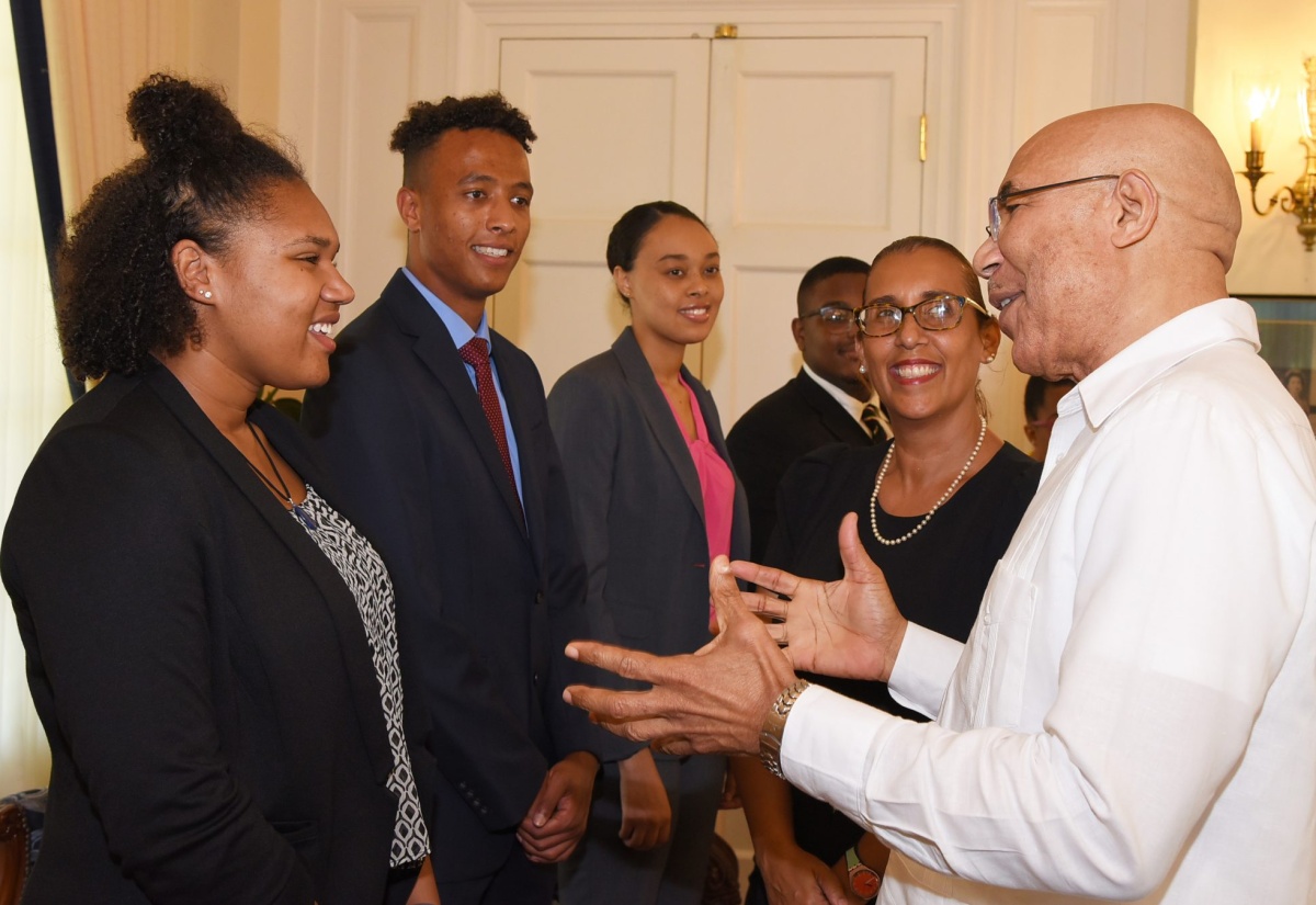 Governor-General, His Excellency the Most Hon. Sir Patrick Allen (right), converses with Canada-based 2019 GraceKennedy Jamaican Birthright Programme intern, Sapphira Thompson-Bled (left), during her visit, with fellow  participants, to King’s House on Friday (July 5). The internship programme is offered to qualified applicants residing in the diaspora who are of Jamaican lineage. It provides educational, professional and cultural exposure, in a working environment, for the participants. Others (from second left) are Callum McCarthy from the United Kingdom; and Kayla Jessup and Tarik Graham from the United States; and Executive Director, GraceKennedy Foundation, Caroline Mahfood.  