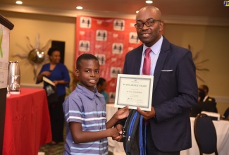 President Elect, Jamaica Teachers’ Association, Owen Speid (right), presents Primary Exit Profile (PEP) scholarship awardee, Aljay Anderson, with his certificate during a TIP Friendly Society scholarship  awards function, held at the Knutsford Court Hotel in St. Andrew, on August 16. He was among 48 scholarship recipients this year.