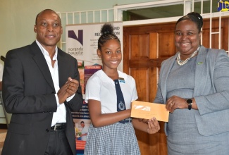 Acting Permanent Secretary in the Ministry of Education, Youth and Information, Dr. Grace McLean (right), makes a presentation to Abrianna Greaves (centre) from Servite Primary in Brown’s Town, St. Ann, who was named the top performing girl at the Noranda Jamaica Bauxite Partners' Primary Exit Profile (PEP) awards ceremony at the Port Rhoades Sports Club, Discovery Bay, St. Ann, on Thursday, August 15. Sharing in the moment is Vice President and General Manager at the company, Delroy Dell. 