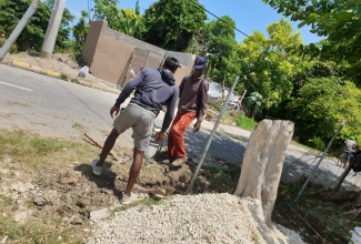 Members of the Salt Spring community in Montego Bay, St. James, erecting a perimeter fence at the Salt Spring Primary and Infant School.