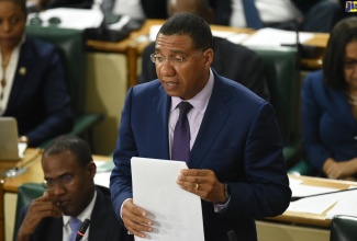 Prime Minister, the Most Hon. Andrew Holness,  addresses the House of Representatives on Tuesday (September 17). At left is Minister of Finance and the Public Service, Dr. the Hon. Nigel Clarke.