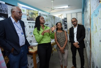 Project Manager for the Vernamfield Development, Lieutenant Colonel Oscar Derby (left), listens keenly as Sana Williams (second left), Master of Architecture student at the University of Technology (UTech) Caribbean School of Architecture (CSA), explains her final-year project. Also pictured (from third left) are Master of Architecture Programme Director, CSA, Mlela Matandara-Clarke; and Programme Director, Bachelor of Arts Architectural Studies, CSA, André Baugh. Occasion was a visit by the Core Implementation Team of the Vernamfield Development project to the school during its 30th anniversary exhibition.