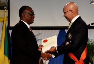 Custos Rotulorum of Manchester, Hon. Garfield Green (left), accepts his Instrument of Office from Governor-General, His Excellency the Most Hon.  Sir Patrick Allen, after being installed at Northers Caribbean University in Mandeville, Manchester, on August 29.