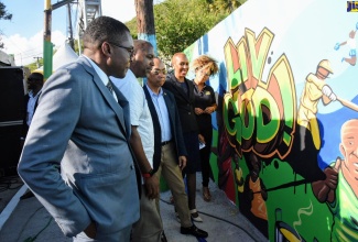 Minister of National Security, Hon. Dr. Horace Chang (third left),  examines a mural that was painted at Roxborough Avenue, Top Range, Mountain View, in Kingston, as part of the Ministry’ s anti-violence campaign dubbed, ‘Liv Gud’. Occasion was the official launch of the campaign at the site on Sept. 13. Others (from left) are: Government Senator and Parliamentary Secretary, Robert Morgan; Member of Parliament for South East St. Andrew, Julian Robinson; Minister of Science, Energy and Technology and Member of Parliament for  Eastern St. Andrew, Hon. Fayval Williams and disc jockey, Tricia ‘ZJ Sparks’ Spence.