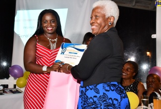 Constable Geraldine Johnson of the Cambridge Police Station in St. James (left) accepts her award for 'Best Police Officer' from wife of the Custos of St. James, Deverly Pitkin, during the Jamaica Constabulary Force (JCF) St. James Division’s ‘Workers of Worth’ awards ceremony held at the White Witch of Rose Hall on Saturday (August 31).