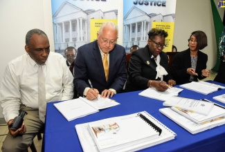 Minister of Justice, Hon. Delroy Chuck (second left) and Director of Public Prosecutions, Paula Llewellyn (second right), sign the contract valued at $626,441,055 for the renovation and expansion of the Office of the Director of Public Prosecutions (DPP). The signing was done on Thursday (September 26) during a quarterly press briefing at the Ministry’s Constant Spring Road offices, in St. Andrew. Observing (from left) are Director, Y.P Seaton and Associates Company Limited, Calvert Mundle and Permanent Secretary in the Ministry, Sancia Bennett Templer.