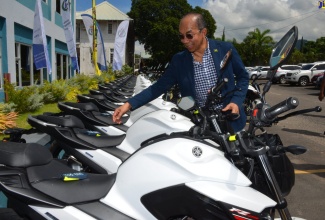 Minister of National Security, Hon. Dr. Horace Chang, looking at one of the new motorcycles that were handed over to the Public Safety and Traffic Enforcement Branch (PSTEB), at a ceremony on Friday (September 20,) at the Office of the Commissioner of Police, Old Hope Road, St. Andrew.