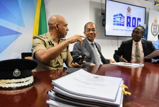 Minister of National Security, Hon. Dr. Horace Chang (centre), engages in a light moment with (from left) Commissioner of Police, Major General Antony Anderson; and Head, Corporate Services, National Security Ministry, Delroy Simpson. Occasion was a contract-signing ceremony for the renovation of 14 police stations across the island, held at the Ministry's Oxford Road offices on Wednesday (September 11). 