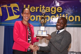 Chief Executive Officer of the Jamaica Information Service (JIS), Donna-Marie Rowe, presents The Mico University College student, Yone Gordon, with his trophy for winning the photography segment of the JIS 2019 Heritage Competition. Occasion was the awards ceremony held on Monday (November 25), at the Mona Visitors’ Lodge, University of the West Indies (UWI), St. Andrew.