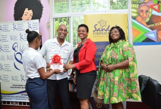 Sandals Foundation Ambassador, Ian Spencer (second left), Public Relations and Communications Manager at the Women’s Centre of Jamaica Foundation (WCJF) Latoya Rattary (second right), and Cosmetology Teacher Rondene Robertson (right), share a moment with a student at the WCJF’s  Montego Bay branch in St. James on Tuesday (November 26). 