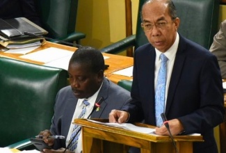 National Security Minister, Hon. Dr. Horace Chang, addresses the House of Representatives on December 10.  Seated at left is Minister of Transport and Mining, Hon. Robert Montague.

