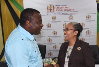 Permanent Secretary in the Ministry of Labour and Social Security, Colette Roberts Risden (right), engages in a light moment with the longest participant in the Seasonal Agricultural Workers Programme, George Blackwood, who has been travelling to Canada for job opportunities under the programme for over 20 years. Occasion was a send-off ceremony at the Ministry of Labour and Social Security’s Overseas Employment Services Centre on Friday (January 3). Mr. Blackwood is among 228 workers who will be leaving the island between now and Monday (January 6), to work in Canada. 

