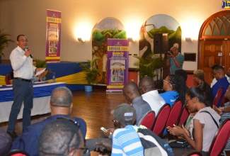 Minister of Health and Wellness, Dr. the Hon. Christopher Tufton (left), addresses persons attending the Ministry’s St. James Town Hall Meeting at the Montego Bay Cultural Centre in Sam Sharpe Square on Thursday (February 6).